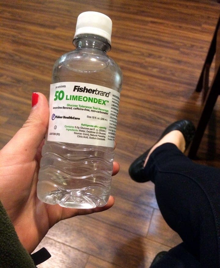 A hand holding a bottle of liquid 