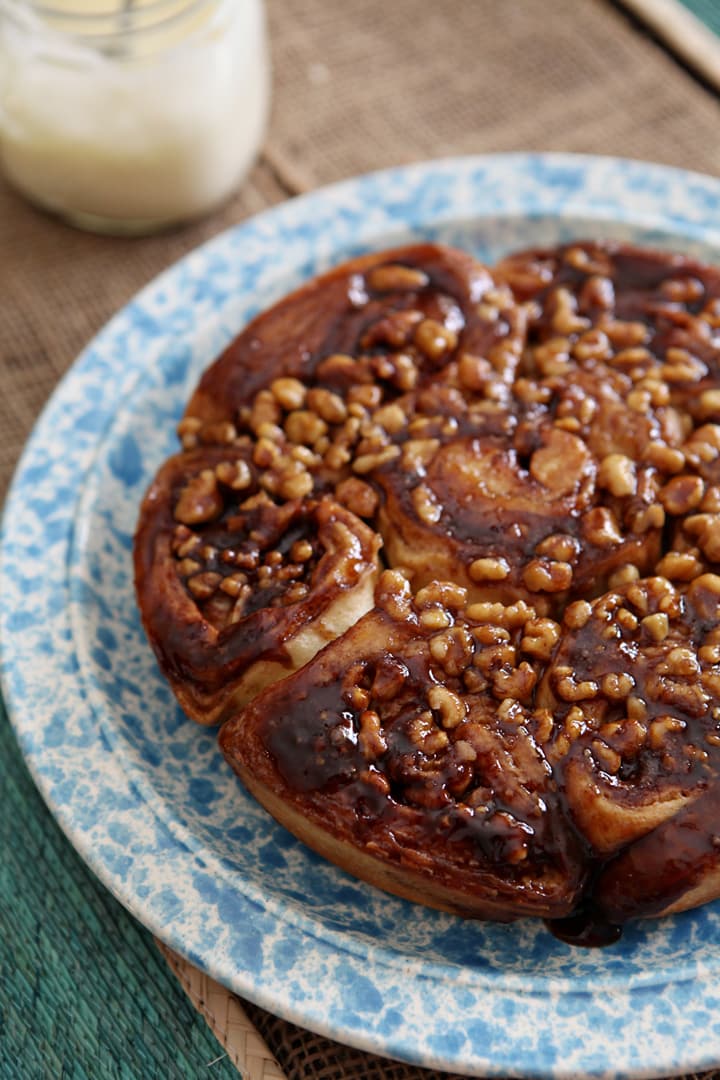 Close up of walnut sticky buns on blue speckled plate 