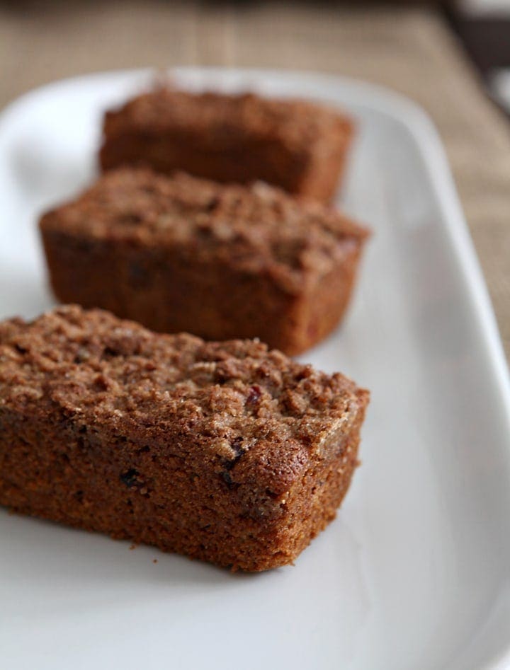 Three pieces of cranberry walnut bread on white serving plate 