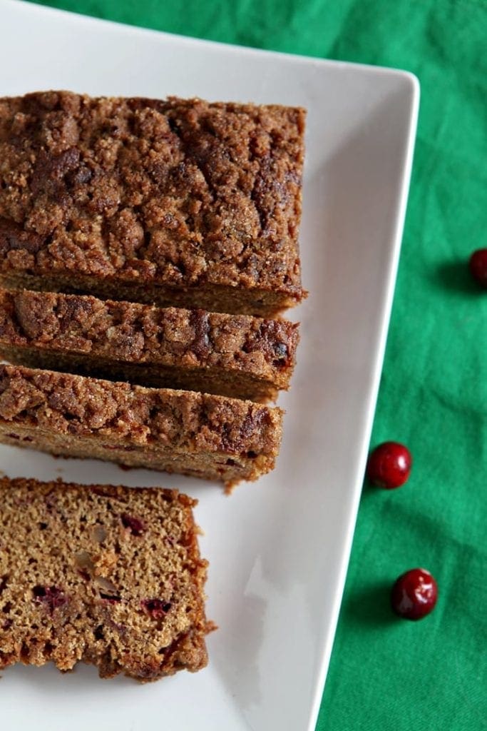 Sliced cranberry walnut bread on white serving dish 