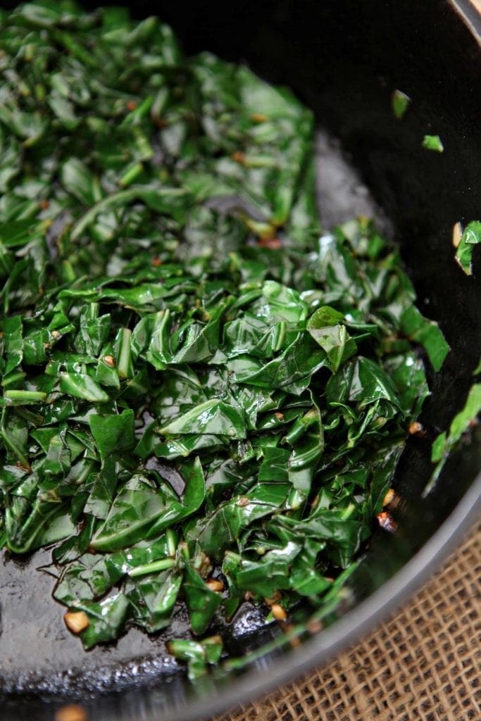 Bacon Collard Greens in a cast iron skillet before serving