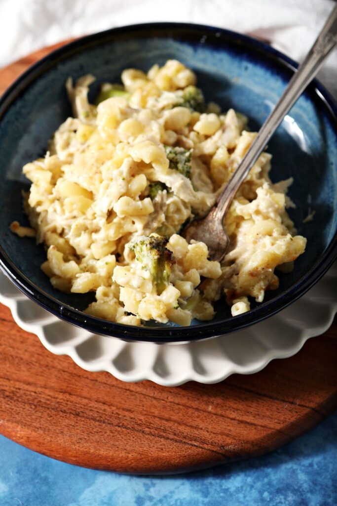 A bowl of Chicken Broccoli Macaroni and Cheese with a fork in it