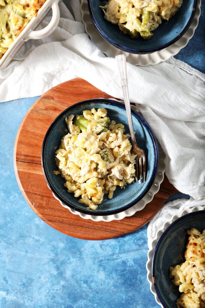 Three blue bowls holding servings of Broccoli Chicken Macaroni and Cheese