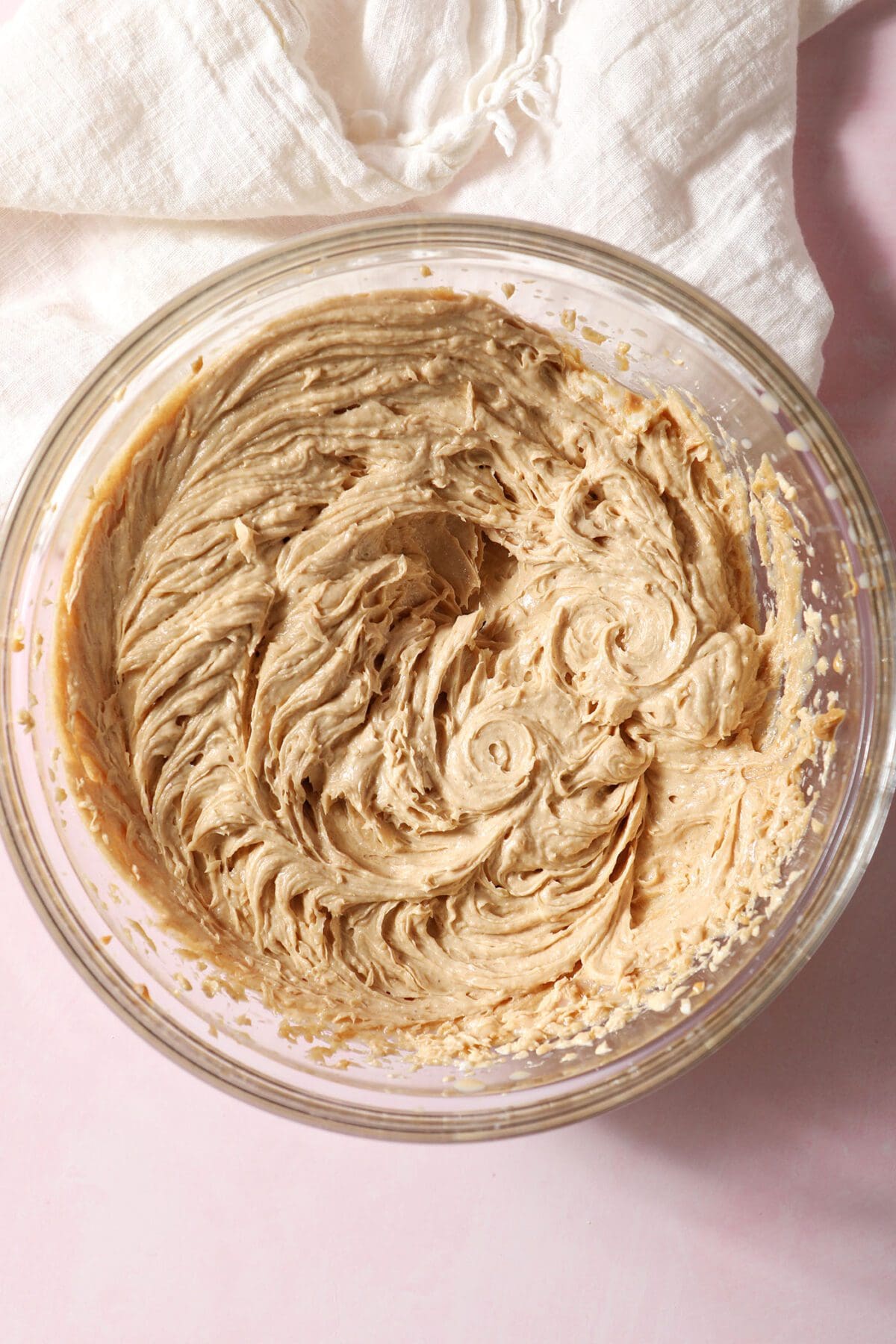 Whipped wet ingredients in a bowl for shortbread cookies on pink marble