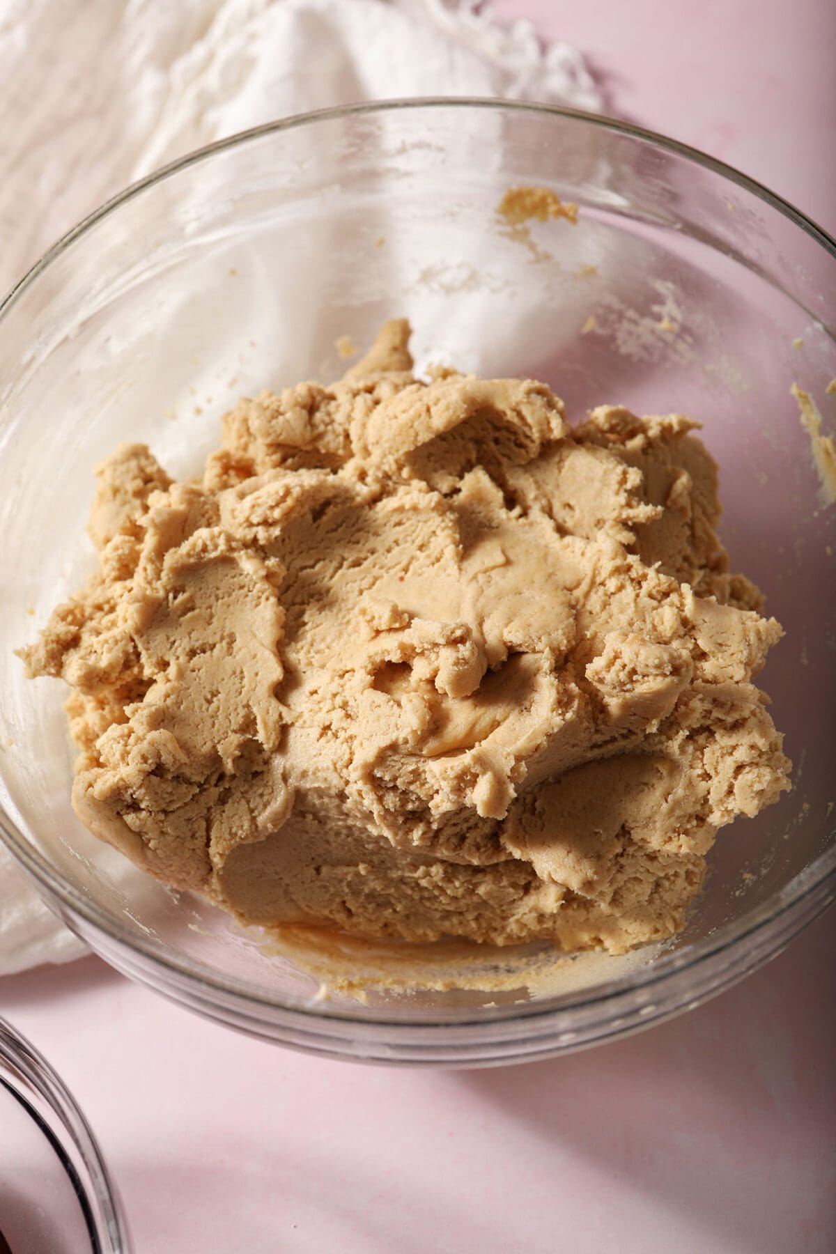 Peanut butter shortbread cookie dough in a bowl on a pink countertop