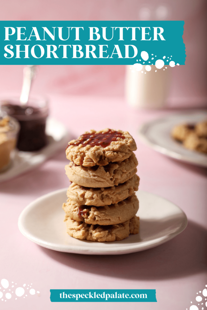 Stacked peanut butter shortbread cookies with raspberry glaze on a white plate on a pink countertop with the text peanut butter shortbread