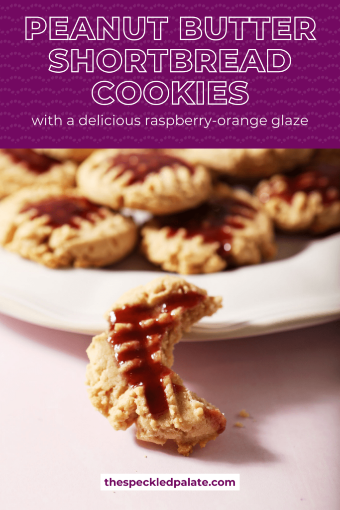 A bitten into raspberry-glazed cookie next to a platter of more cookies with the text peanut butter shortbread cookies with a delicious raspberry-orange glaze