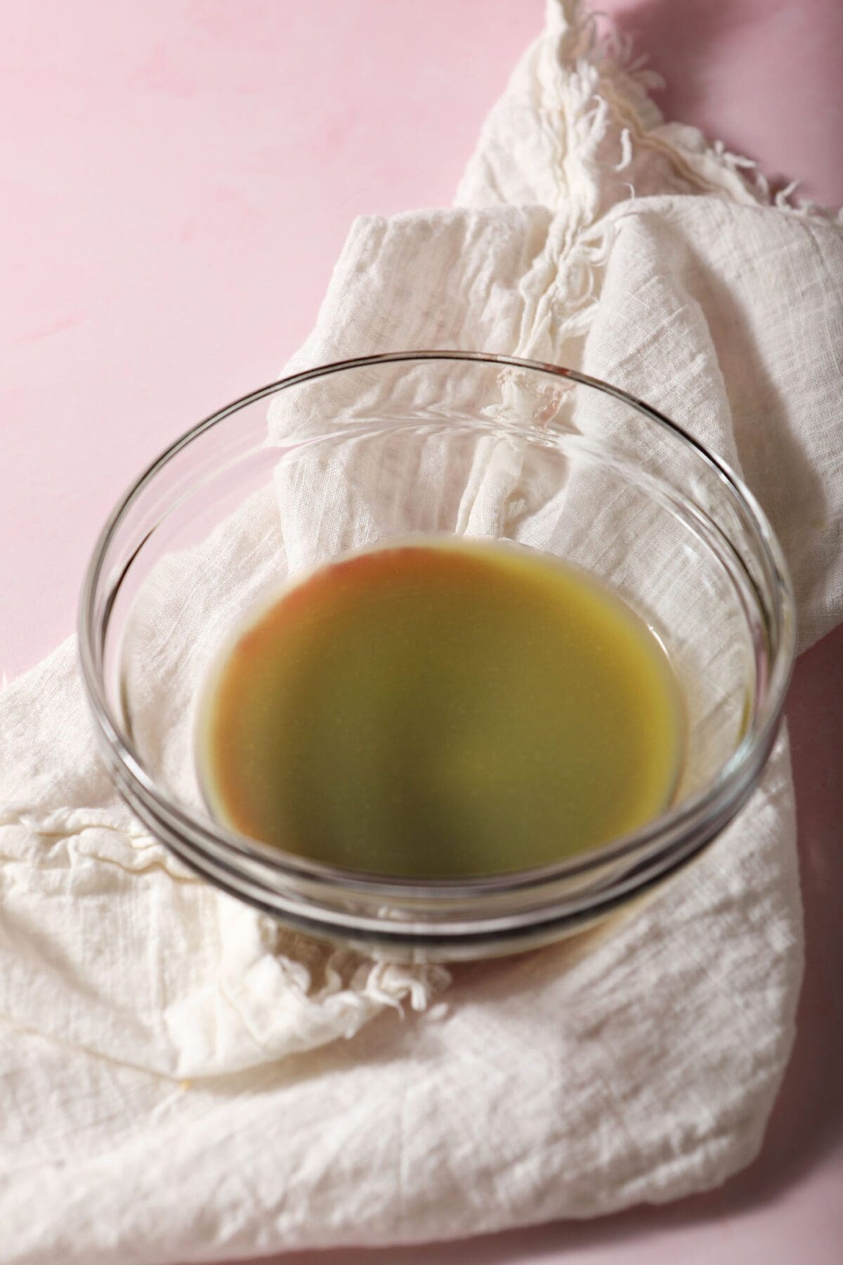 Orange juice on top of raspberry jam in a bowl to make a glaze