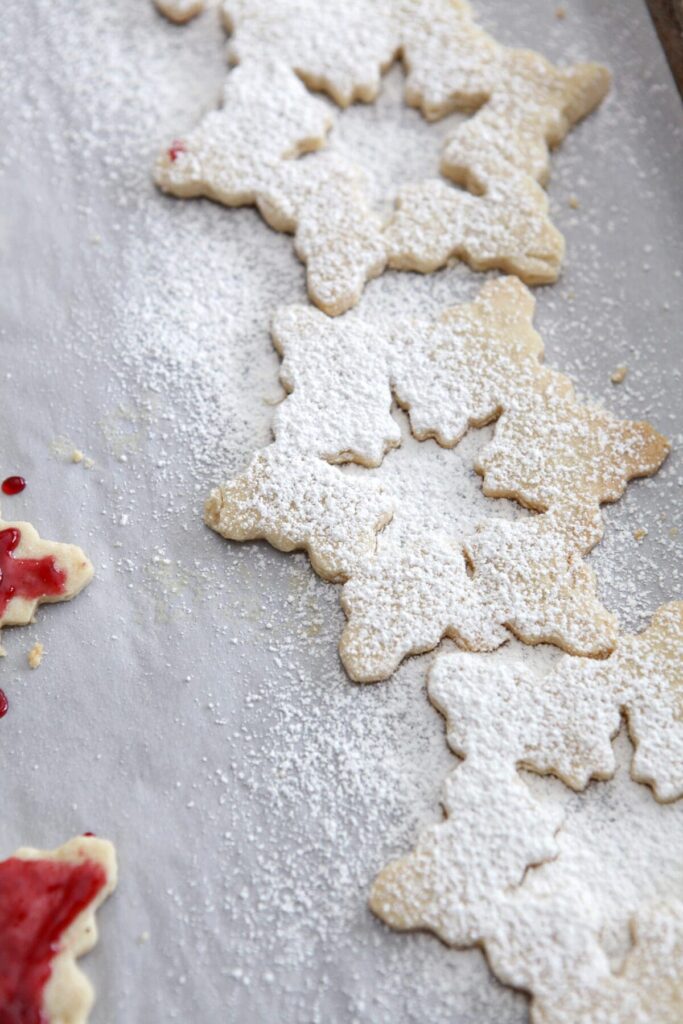 Snowflake-shaped top cookies for sandwich cookies on a sheet pan