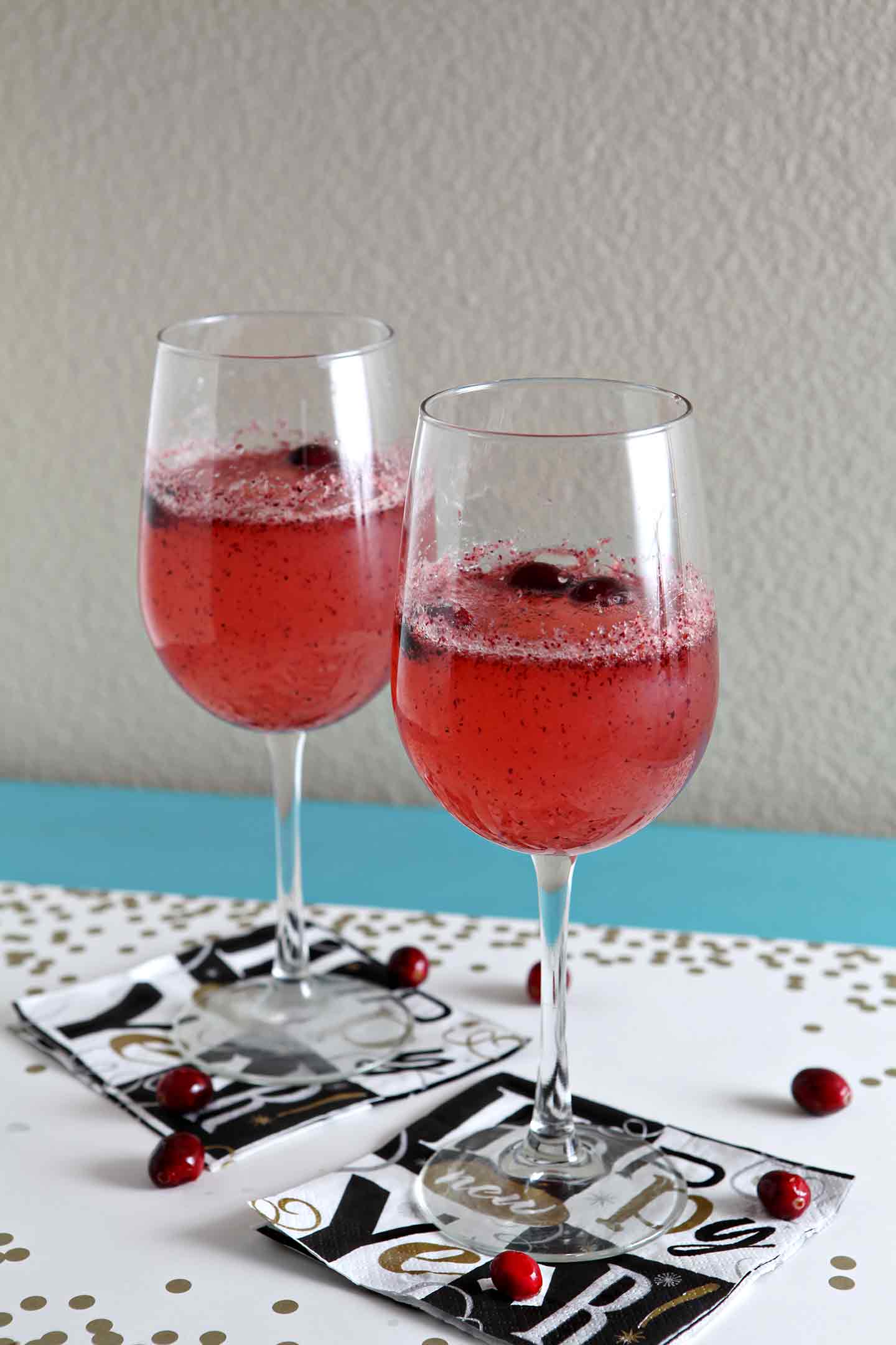 Two glasses of sparkling cranberry mocktails on new year's eve glasses