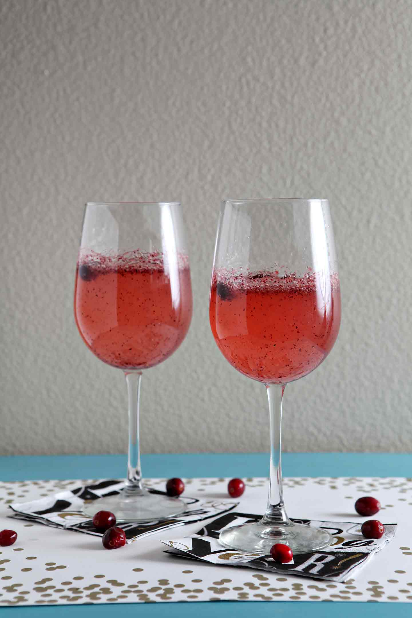 Two glasses of sparkling cranberry mocktails on new year's eve napkins