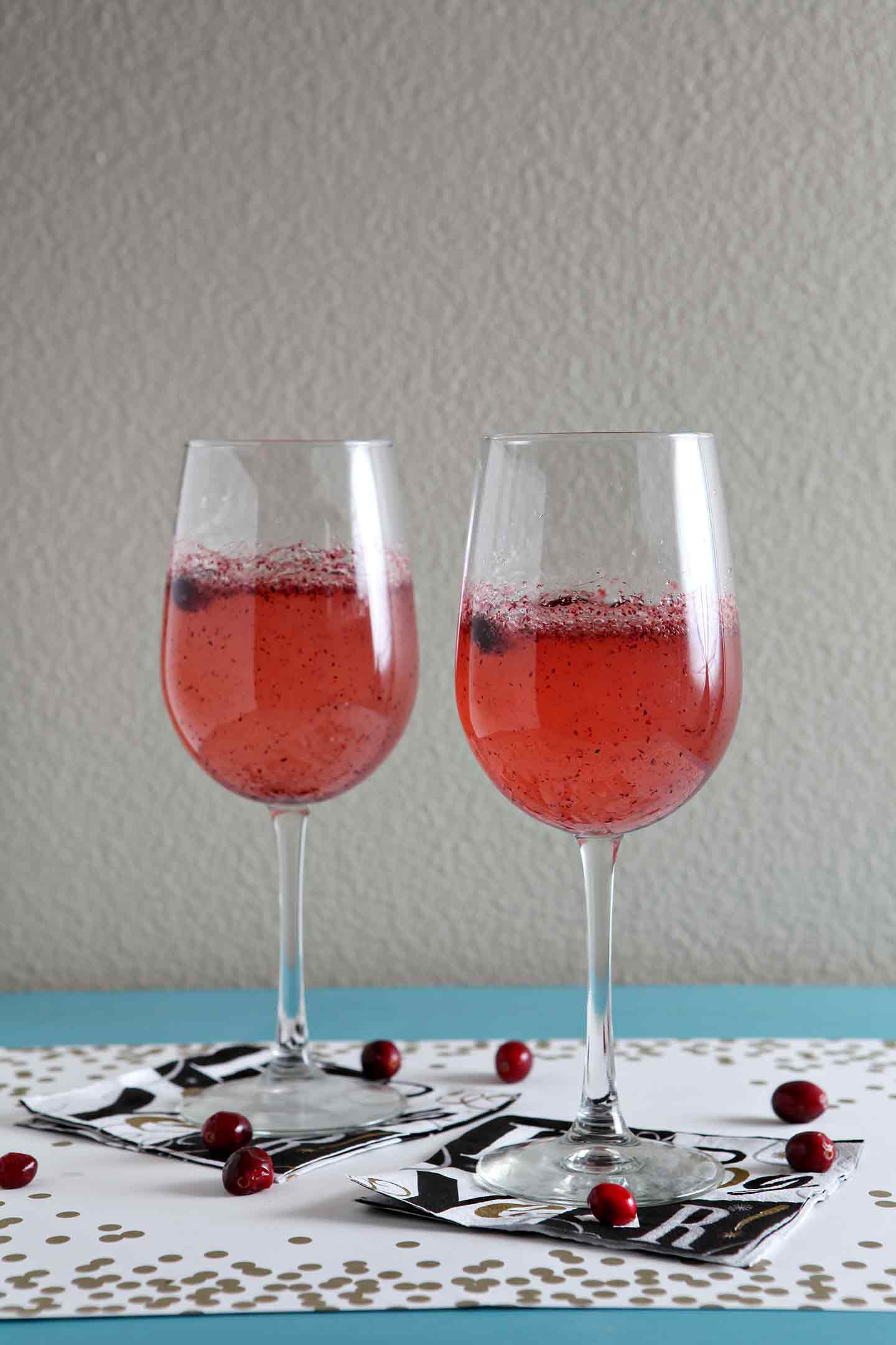 Two glasses of sparkling cranberry mocktails on new year's eve napkins 