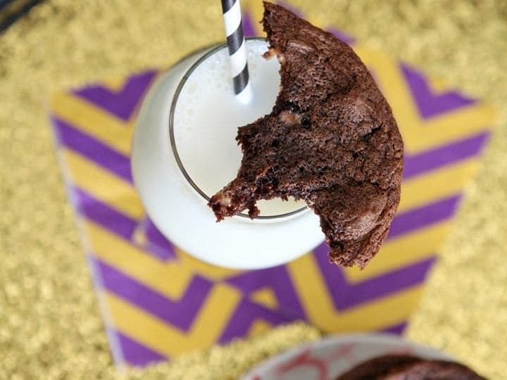 Overhead view of chocolate cookie on top of glass of milk