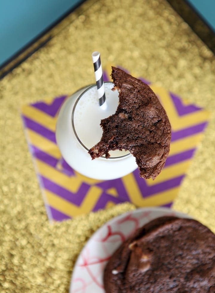 Overhead view of chocolate cookie on top of glass of milk 