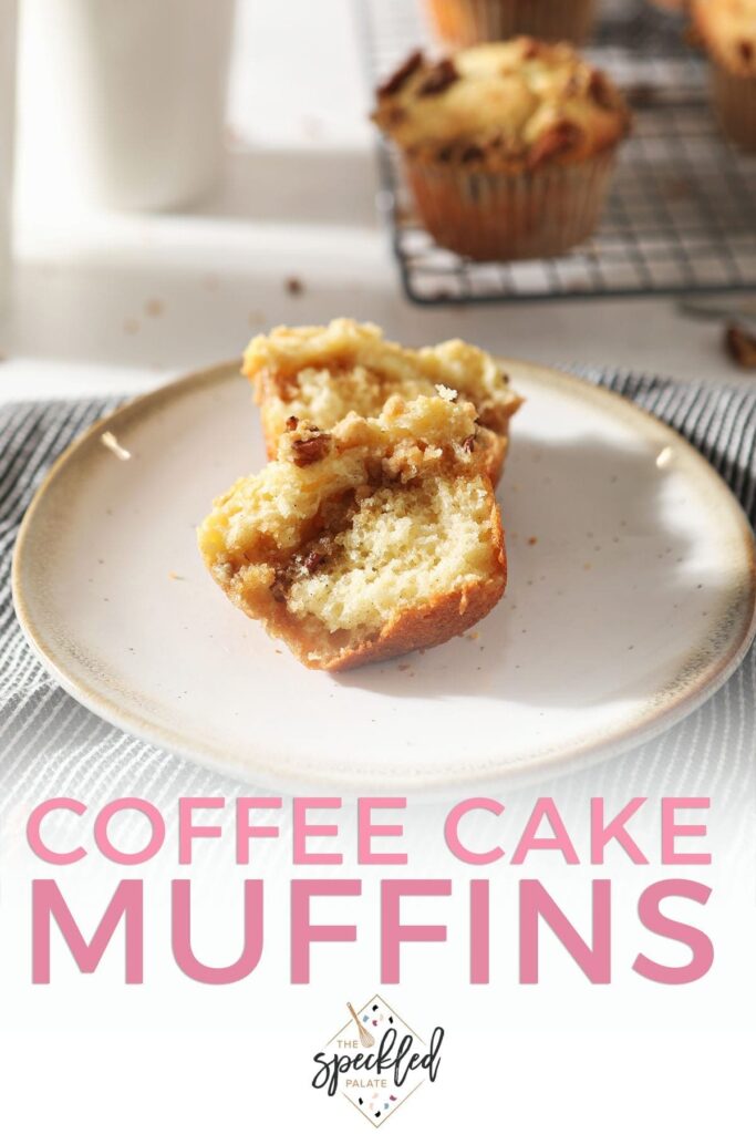 A halved Coffee Cake Muffin sits on a pottery plate in front of coffee mugs and a wire cooling rack holding more muffins with the text 'coffee cake muffins'