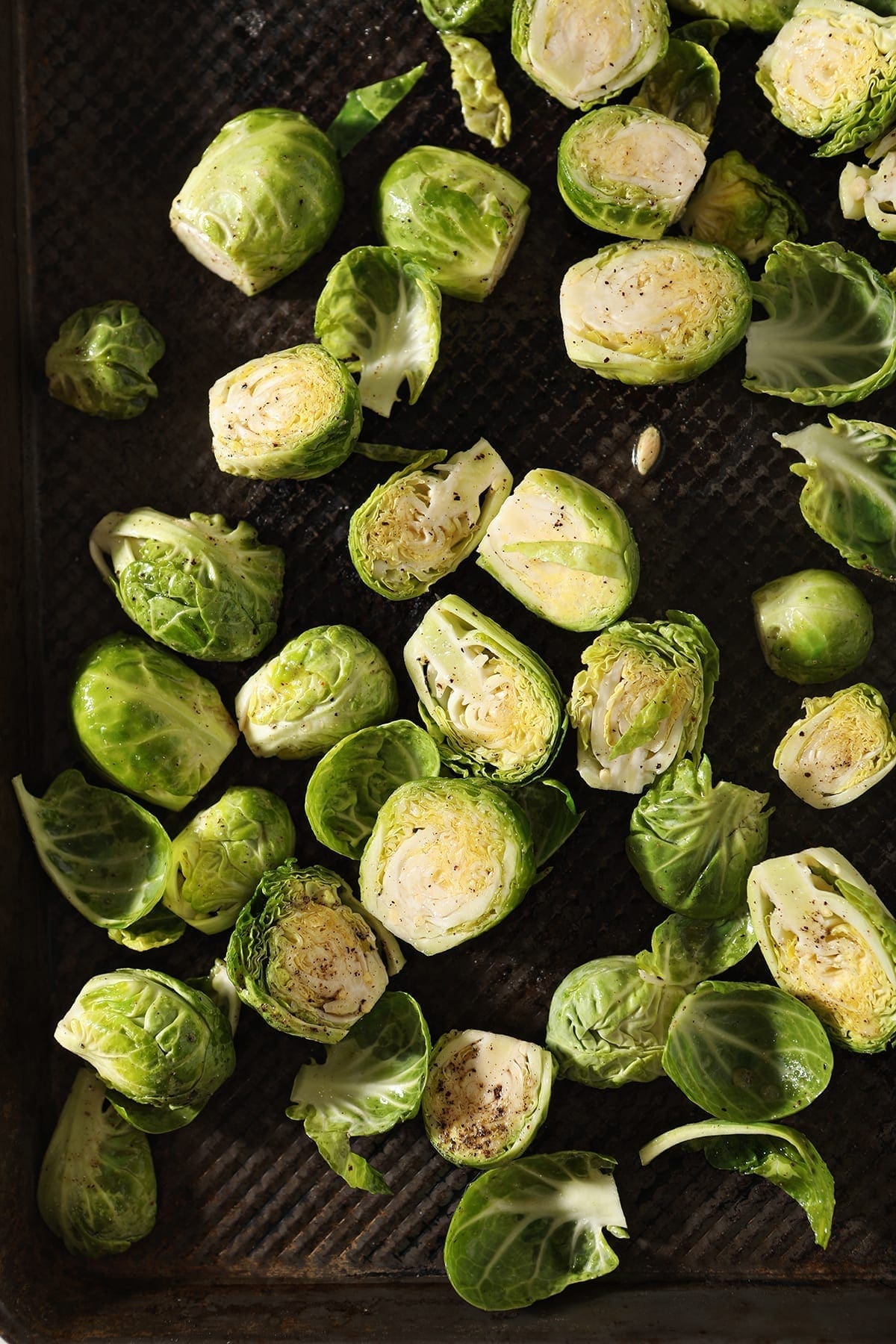 Brussels sprouts on a baking sheet before baking