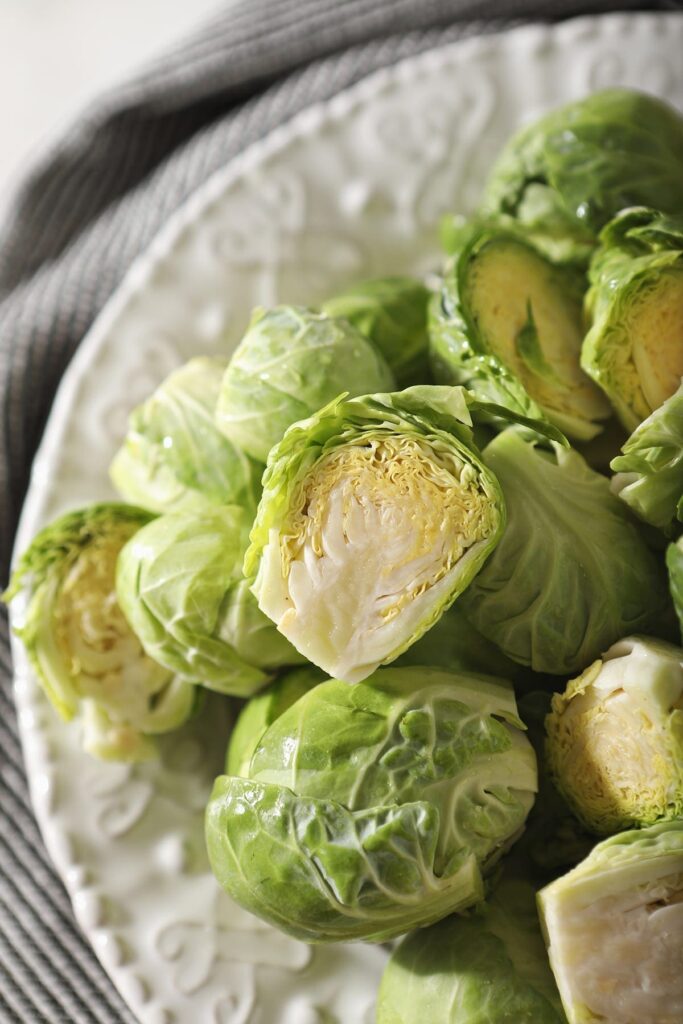 brussels sprouts on a white plate before roasting