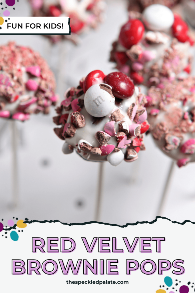 Several pops covered in red, pink and white candies with the text Red Velvet Brownie Pops