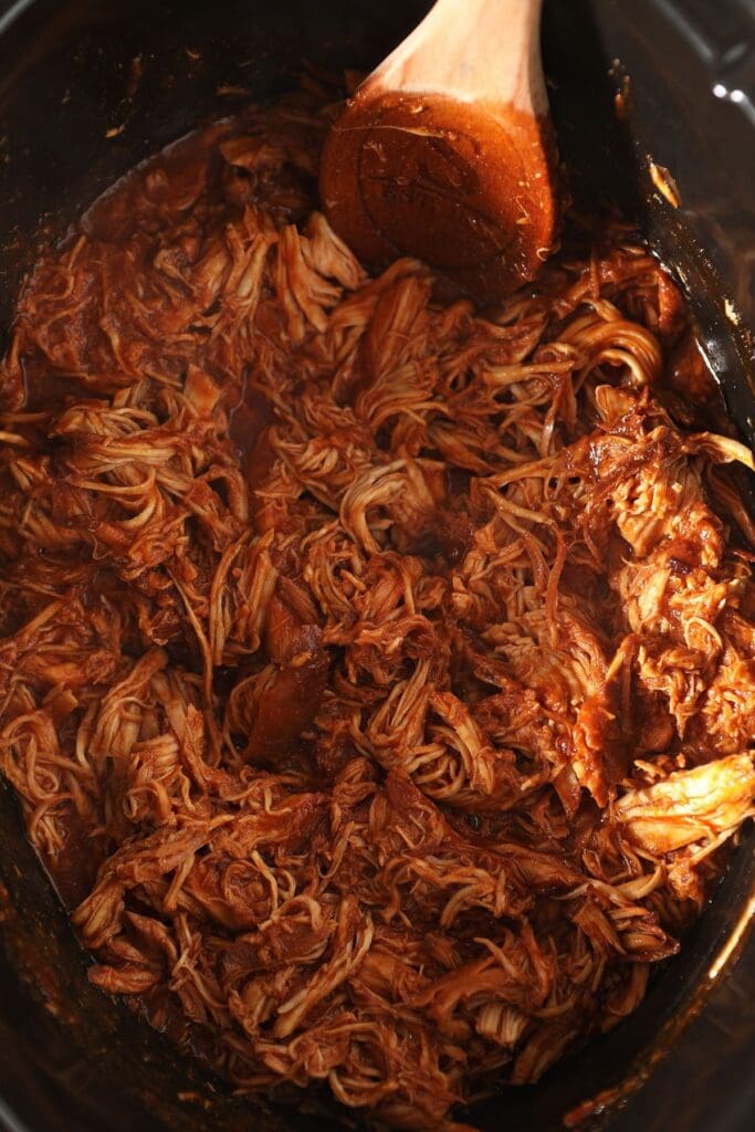 Shredded BBQ chicken in a slow cooker in sauce