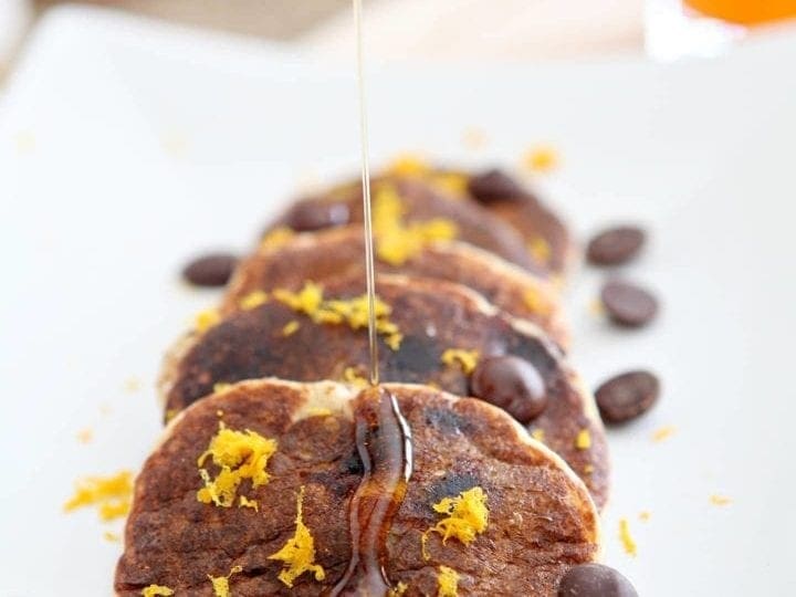 Syrup is drizzled onto Dark Chocolate Satsuma Pancakes from above