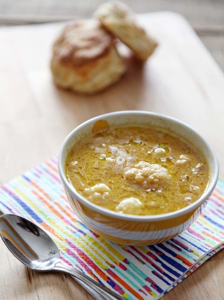Bowl of soup on napkin in front of bread 