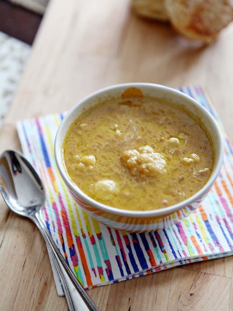 Bowl of soup with spoon on wood table 