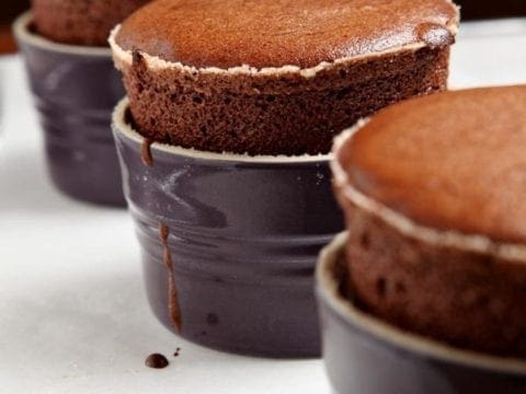 Three Dark Chocolate Souffles sit on a baking sheet