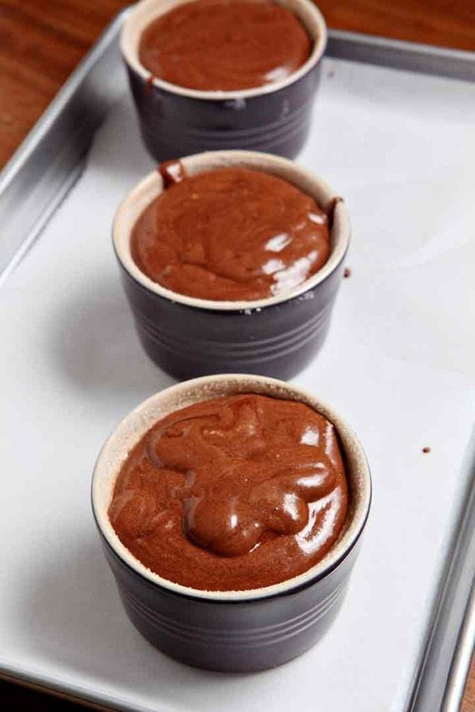 Souffle batter in ramekins before baking on a sheet pan