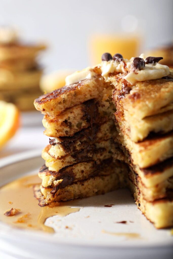 Close up of the inside of a stack of Orange Pancakes with Chocolate Chips on a plate