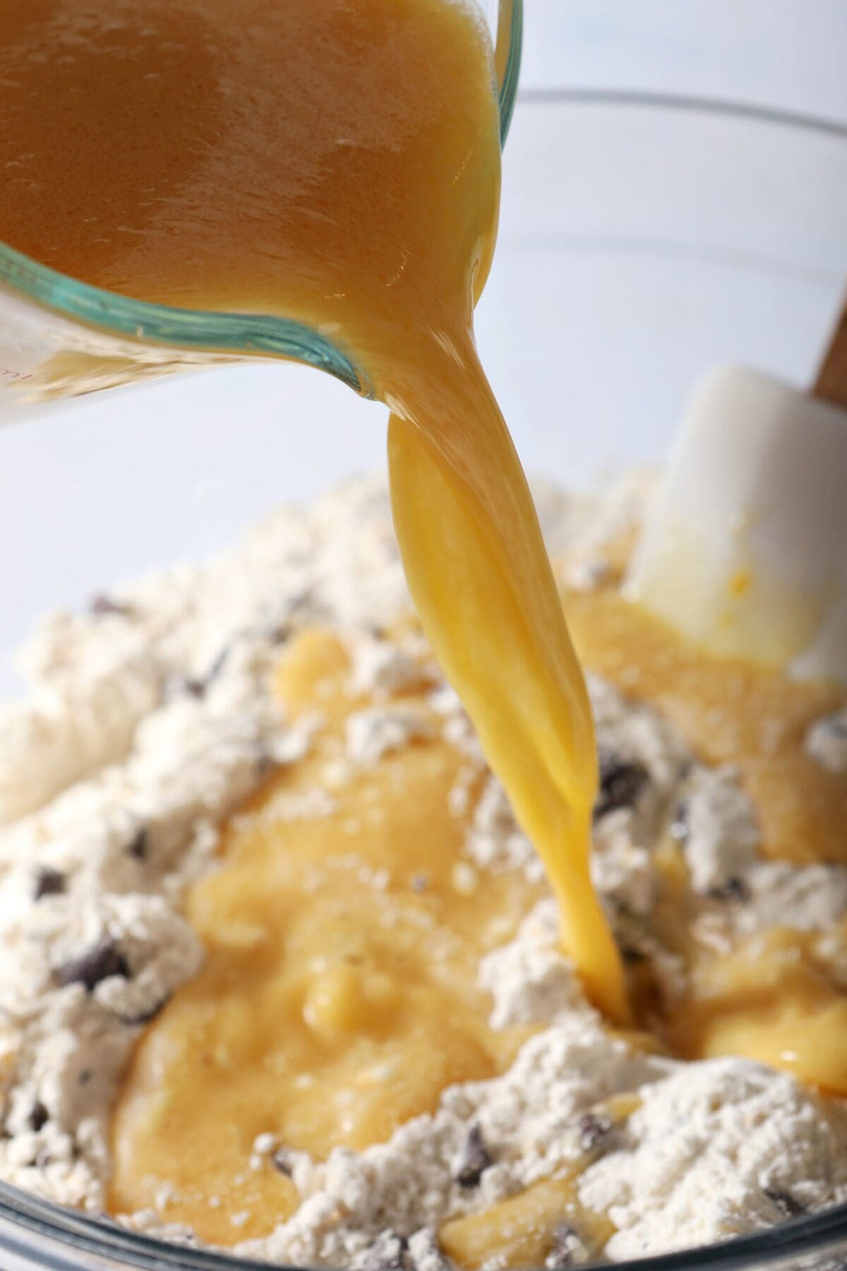 Wet ingredients, including orange juice, pour on top of the dry pancake ingredients