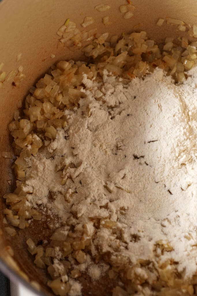 Flour on top of veggies in a Dutch oven