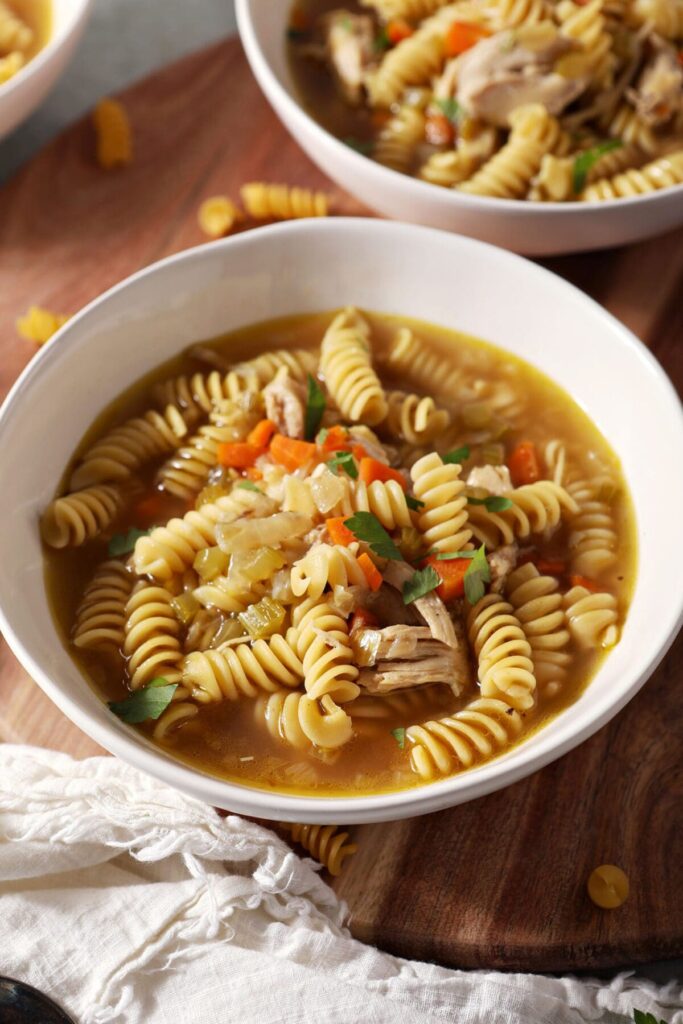 Close up of two bowls of Chicken Noodle Soup with Rotisserie chicken