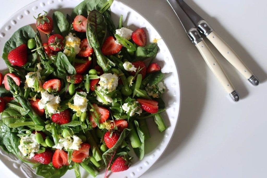 Overhead view of Spring Pea, Asparagus and Strawberry Salad in white bowl  