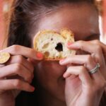 A woman looking through a hole from a small piece of bread 