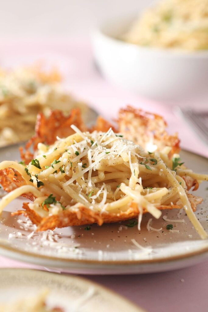 Cacio e pepe sits in a parmesan cheese bowl on a plate