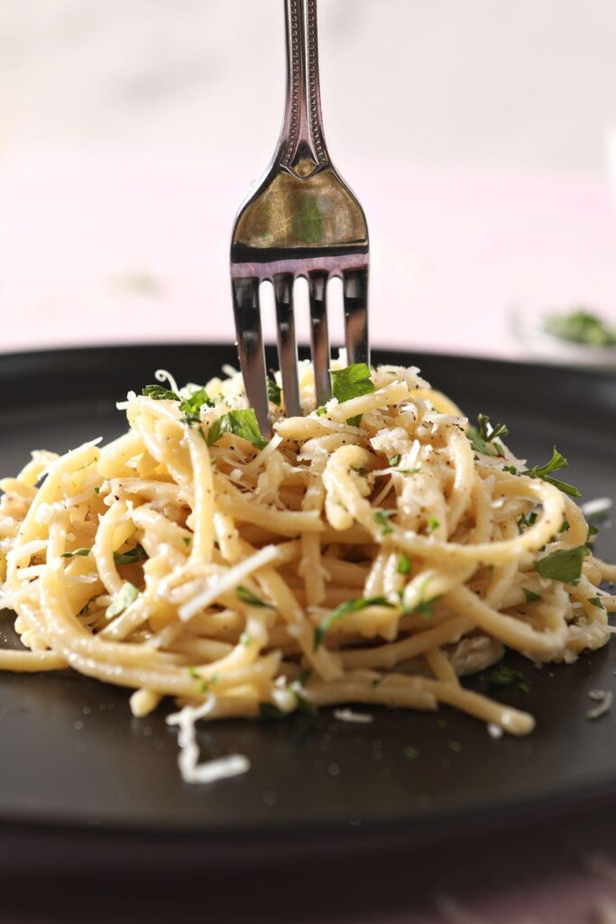 A fork twirls in a stack of pasta