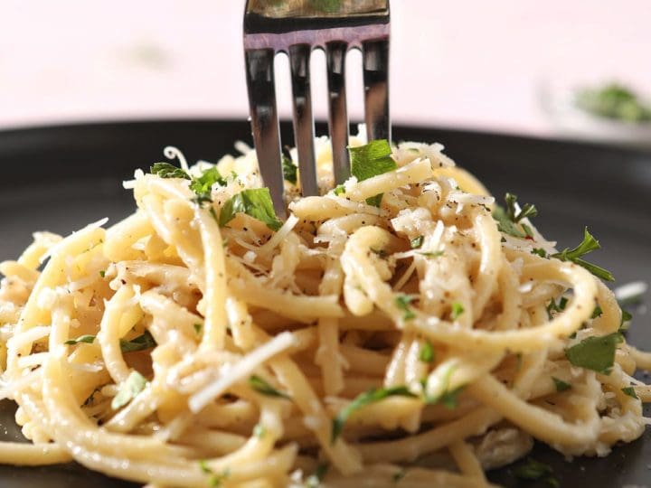 A fork twirls in a stack of pasta