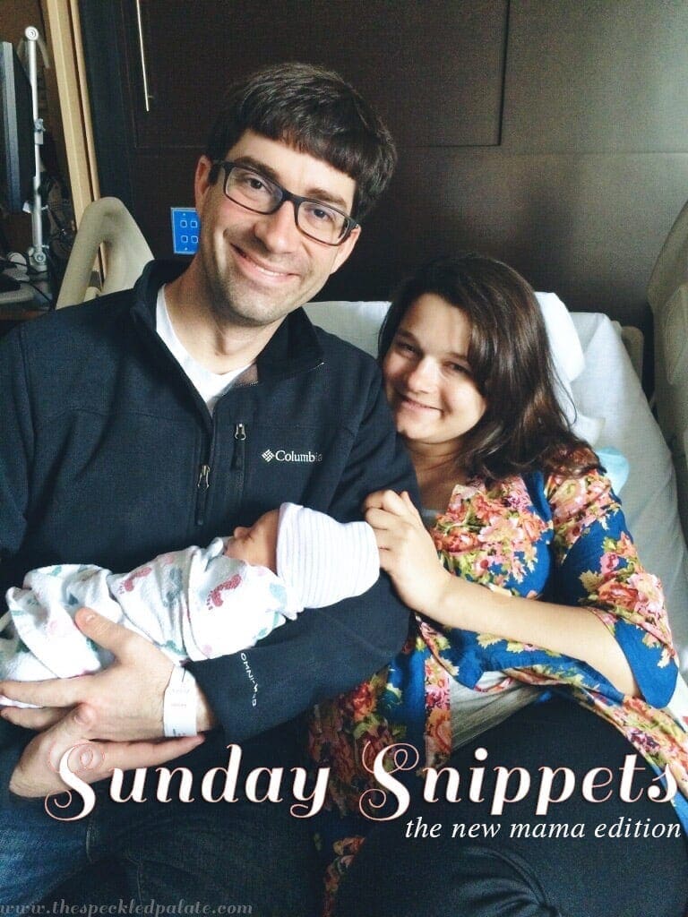 Picture of Dad holding a new born baby next to mother in hospital bed 