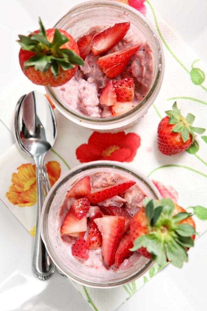 strawberry overnight oats in glass jars with spoons