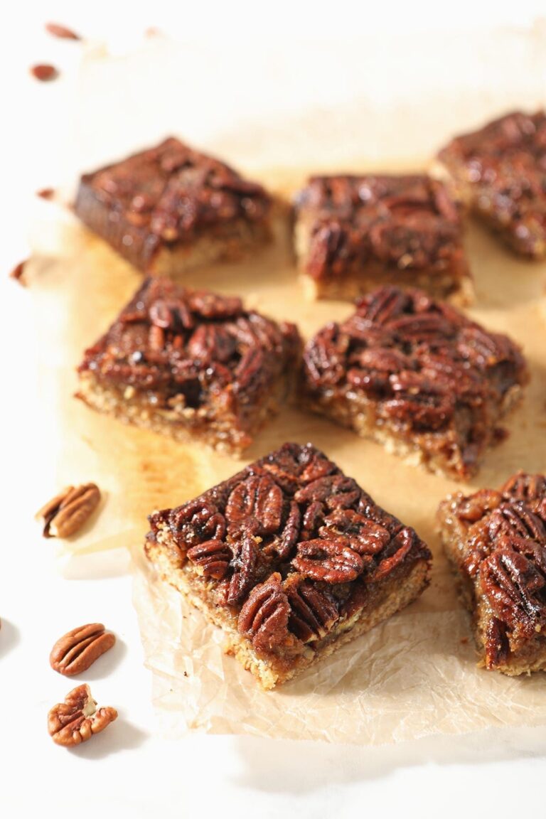 Sliced Bourbon Pecan Pie Bars sit on wax paper
