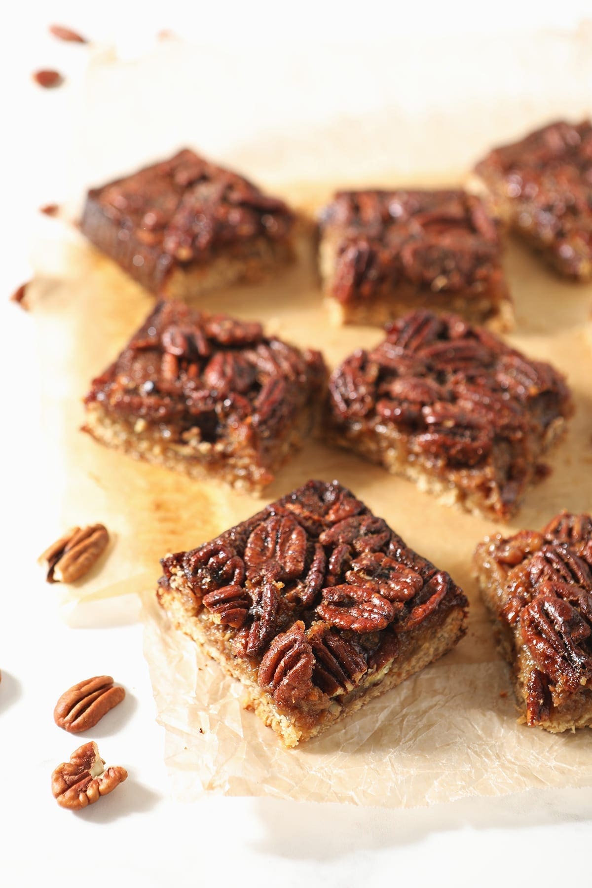 Sliced Bourbon Pecan Pie Bars sit on wax paper