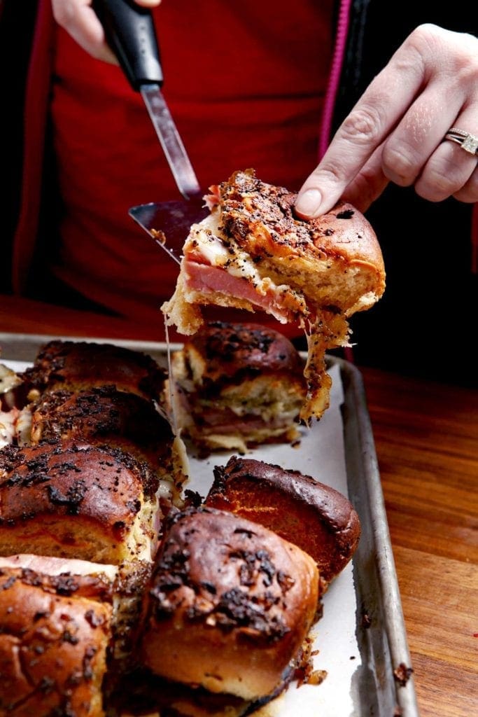 Gooey Ham Goo Sandwiches being served out of the baking sheet, which just came out of the oven. Cheese is gooey and the sandwiches look TASTY.