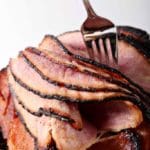 A fork peels layers of a homemade honey ham for Easter and other holidays