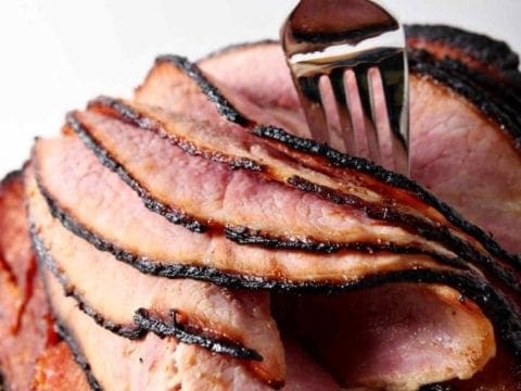 A fork peels layers of a homemade honey ham for Easter and other holidays