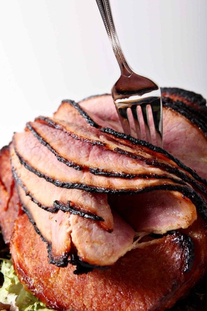 A fork peels layers of a homemade honey ham for Easter and other holidays