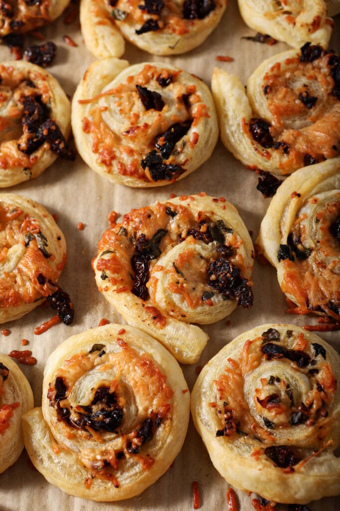 Bruschetta puff pastry pinwheels on a sheet pan after baking