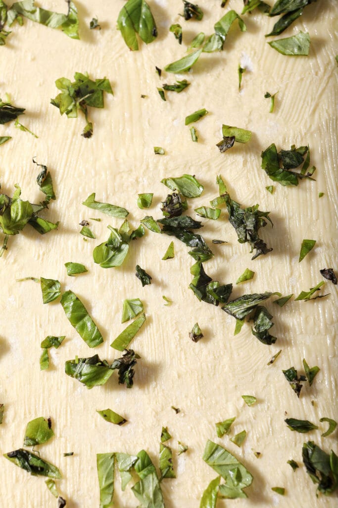 Butter and fresh basil on rolled out puff pastry