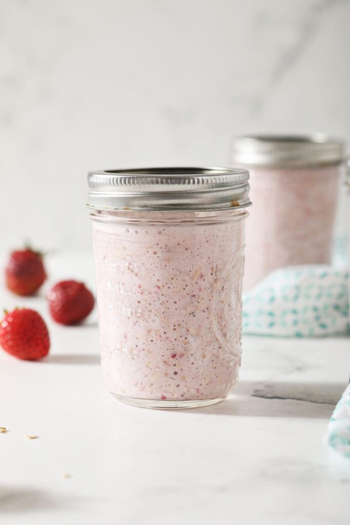 A serving of strawberry overnight oats in a mason jar, before refrigerating