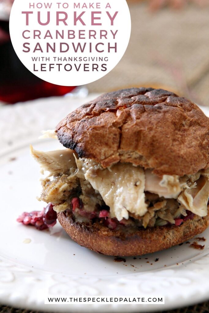 Close up of a sandwich with cranberry, turkey, stuffing and more on a white plate with the text 'how to make a turkey cranberry sandwich with thanksgiving leftovers'