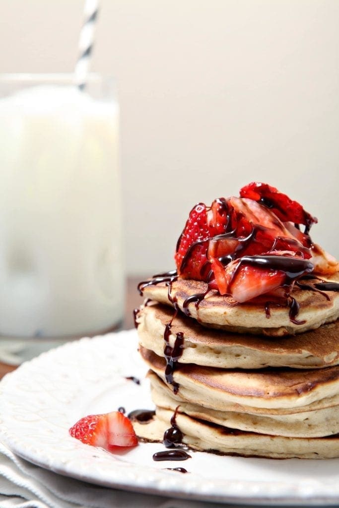 Strawberry Dark Chocolate Pancakes | Surprise your mom (or any special lady in your life!) with Strawberry Dark Chocolate Pancakes in bed for Mother's Day! A classic pancake recipe, topped with fresh strawberries and melted dark chocolate, is the way to start her day the best way this weekend.